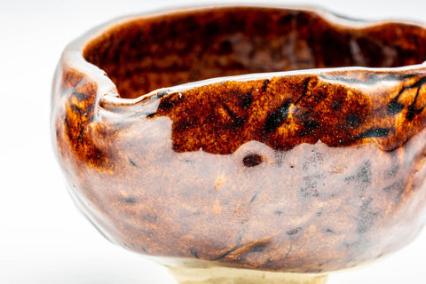 Close-up of the katakuchi pouring lip and the mottled burgundy glaze surface