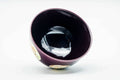 Three-quarter view looking into the bowl, showing the dark purple glazed interior.