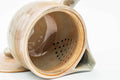 Interior view of the beige Hagi-yaki kyusu showing the perforated do-ake strainer holes near the spout