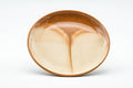 The matching coaster shown from above, displaying the drip-glaze pattern in its well.