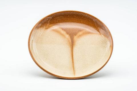 The matching coaster shown from above, displaying the drip-glaze pattern in its well.