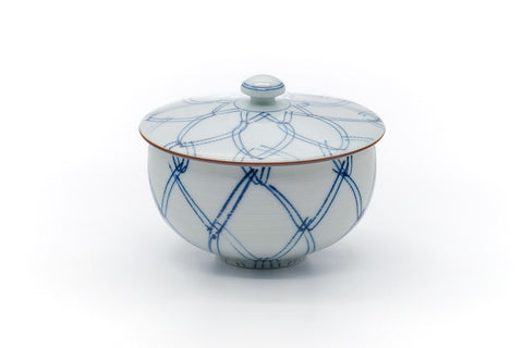 The lidded cup at a slight angle, showing the blue geometric design.