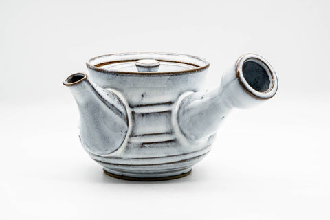 Three-quarter rear view showing the hollow side handle and the banded white-glazed body.
