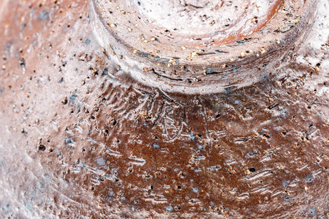 Close-up of the bowl's wall, showing the mottled, textured brown glaze.