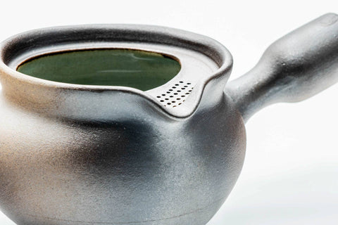 Three-quarter view of the dark yohen kyusu showing the metallic gradient glaze and open top