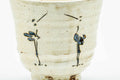 Three-quarter view showing the egret motifs around the body.