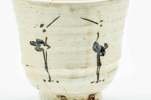 Three-quarter view showing the egret motifs around the body.
