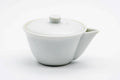 Three-quarter view of the white porcelain houhin with the lid on, showing its short spout.