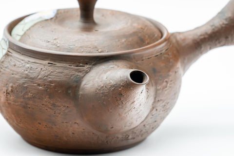 Elevated view of the teapot with the lid in place and handle extended.