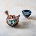 The teapot shown beside a small blue cup for scale.