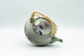 Japanese Tea Set - Green Arita-yaki Debeso Dobin Teapot with 2 Lidded Yunomi Teacups - angled view of the teapot showing the handle and plum blossom decoration