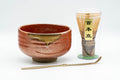 Japanese Matcha Bowl Set - Tanaka Kayama Ochre Glazed Hantsutsu-gata Chawan with Bamboo Chasen Whisk and Chashaku Scoop - 450ml - full set arranged with the red matcha bowl, dark bamboo whisk and scoop on a stand