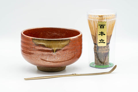 Japanese Matcha Bowl Set - Tanaka Kayama Ochre Glazed Hantsutsu-gata Chawan with Bamboo Chasen Whisk and Chashaku Scoop - 450ml - full set arranged with the red matcha bowl, dark bamboo whisk and scoop on a stand