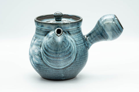 The blue teapot from another angle, handle to the right and spout forward.
