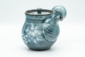 Three-quarter view showing the hollow side handle and spout.