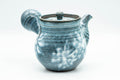 Blue-glazed debeso kyusu teapot with white floral splashes, three-quarter view with lid on and side handle to the right.