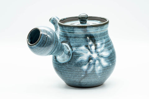 Side profile of the teapot with the spout to the left and handle to the right.