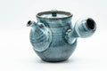 Front view of the teapot, spout facing forward, white floral splash on the blue body.