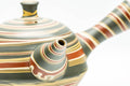 Japanese Kyusu - Green, Red, and Yellow Swirling Nerikomi Tokoname-yaki Do-ake Teapot - 240ml - angled view showing the nerikomi swirl pattern