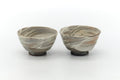 Pair of grey hakeme yunomi, front view with swirled grey, beige and ochre brushwork.