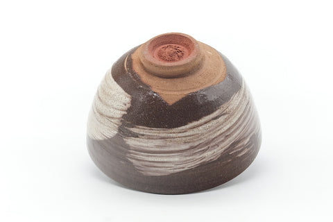 Underside of the chawan showing the foot ring, brushed body and a small maker's stamp.