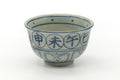 Annan-style matcha bowl (chawan), front view, pale celadon-grey glaze with blue underglaze characters.