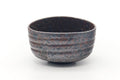 Dark metallic-speckled chawan with a ribbed body, front view.