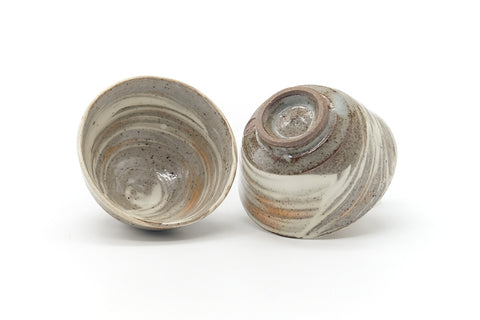The pair from above, one upright showing the interior well and one inverted showing its foot.