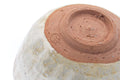 Close-up of the underside showing the reddish foot and drip glaze.