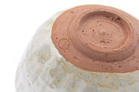 Close-up of the underside showing the reddish foot and drip glaze.
