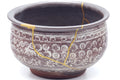 Closeup of the body showing the gold kintsugi seams and chrysanthemum mishima pattern