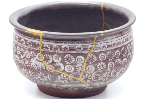 Closeup of the body showing the gold kintsugi seams and chrysanthemum mishima pattern