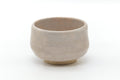 Large off-white matcha chawan with a softly mottled cream glaze, shown from a three-quarter angle.