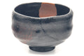 Black raku kintsugi chawan, front view emphasising the red-and-black mottled glaze and gold seam