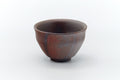 Front view of a small dark-brown Bizen-yaki yunomi with reddish kiln-fired patterning and a defined foot.