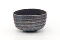 Front view of the earthy chawan showing its ribbed bands and rusty-metallic glaze.
