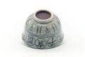 Underside of the chawan showing the unglazed foot and blue characters near the base.