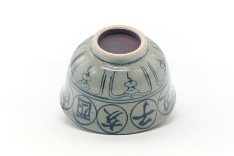 Underside of the chawan showing the unglazed foot and blue characters near the base.