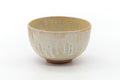 Front view showing the creamy drip glaze with reddish clay at the foot.