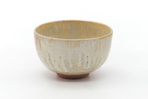 Front view showing the creamy drip glaze with reddish clay at the foot.