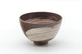Front view of the rounded brown chawan showing the white brushed glaze over its dark surface.
