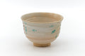 Floral cream chawan, front view showing the scattered painted blossoms over the pale glaze