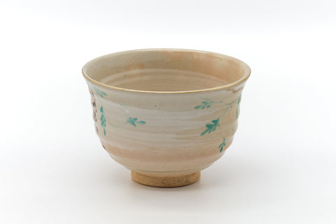 Floral cream chawan, front view showing the scattered painted blossoms over the pale glaze