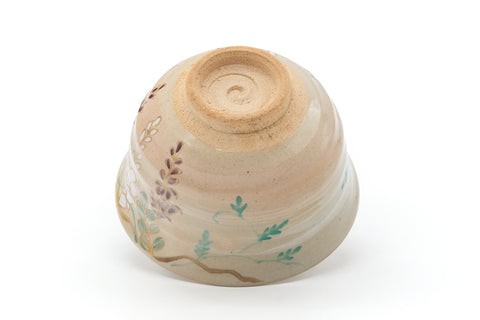 Floral cream chawan inverted to show the underside and spiral-trimmed foot ring (kodai)