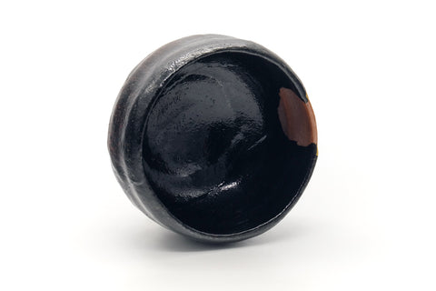 Black raku kintsugi chawan seen from above, looking into the dark glazed interior