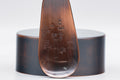 Top-down view of the canister lid and the engraved floral tea scoop.