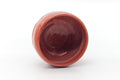 Overhead view into the bowl's deep red glazed interior.