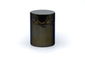 Stainless-steel tea canister, straight-on front view of the closed cylindrical canister with reflective metal surface