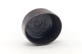 The chawan tilted to show its dark interior with a spiral mark.
