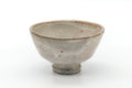 Pale grey-beige Hagi ido-gata chawan with a high foot, front view.